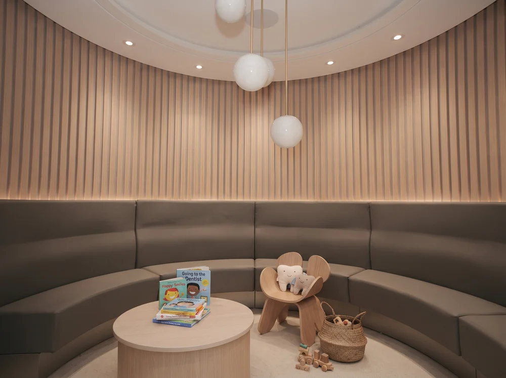 A children’s reading nook in the Smile Studio Dental waiting area, with picture books and plush tooth toys